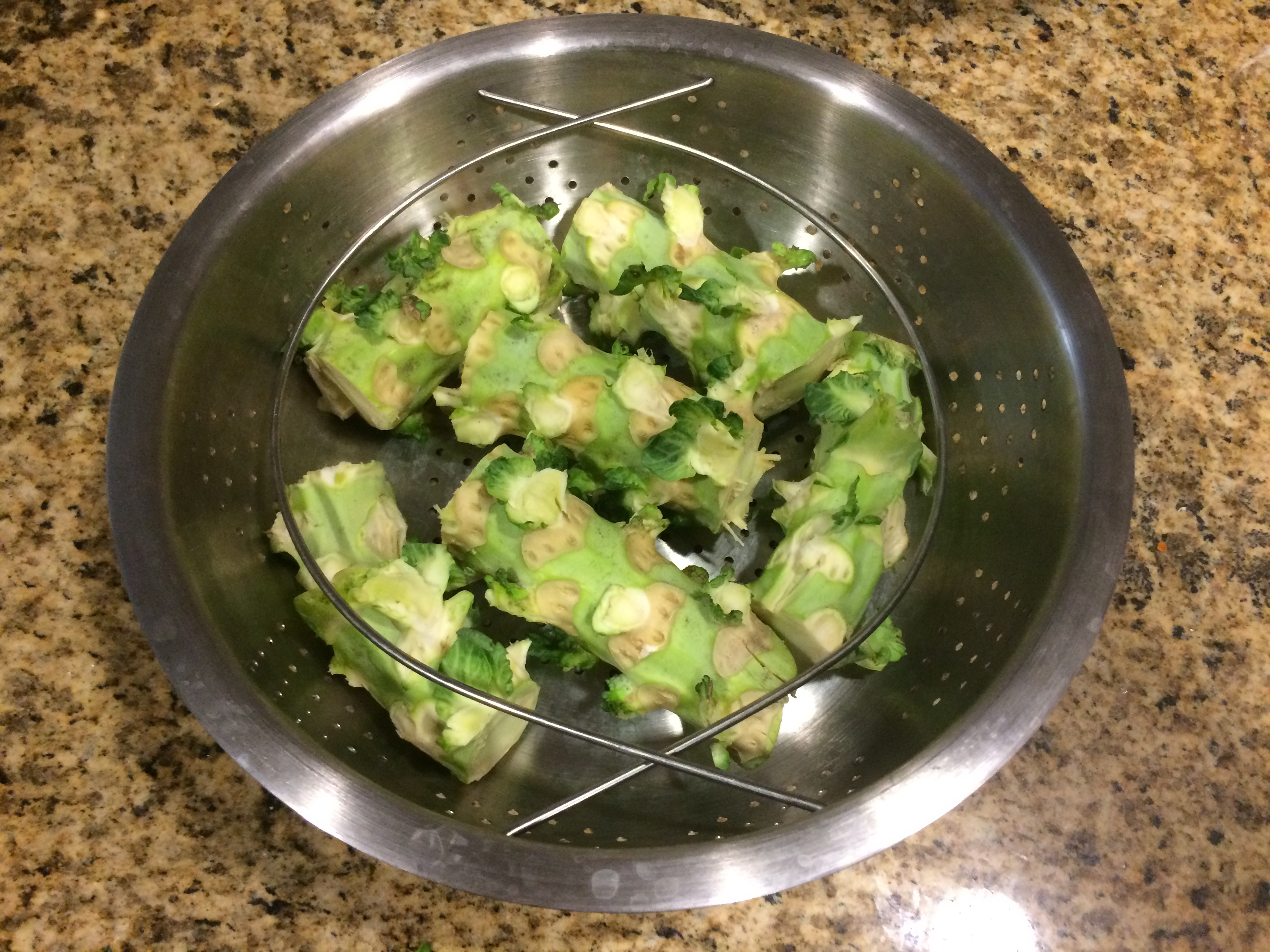 Brussels sprout stalk pieces arranged in a steamer basket